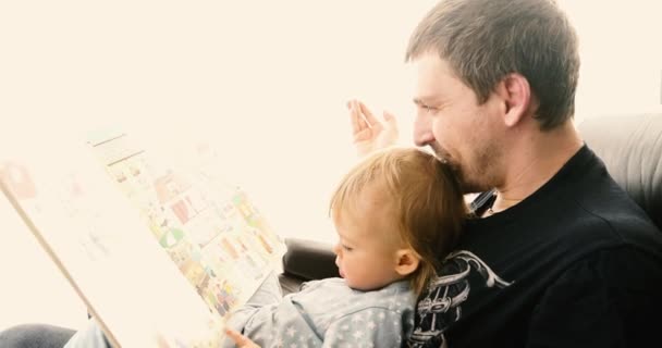 Père et petit garçon avec livre à la maison — Video