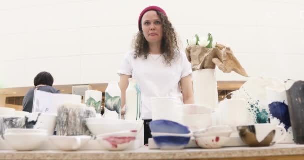 Meisje verkoopt handgemaakte keramiek markt teller — Stockvideo