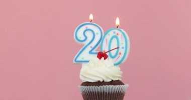 Yirmi 20 mum cupcake pembe arka planda