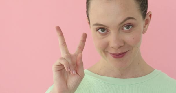 Smiling happy woman showing victory sign — Stock Video