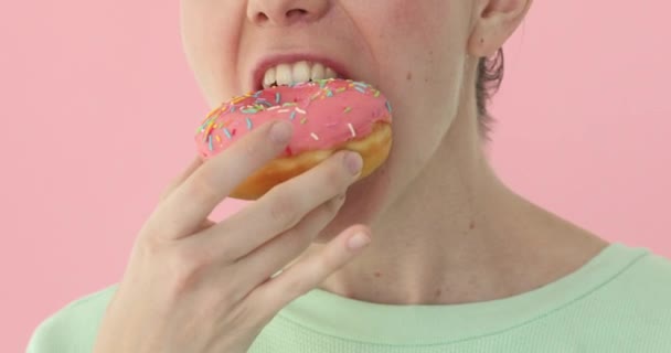 Eten van een donut close-up, heerlijke vrouw — Stockvideo