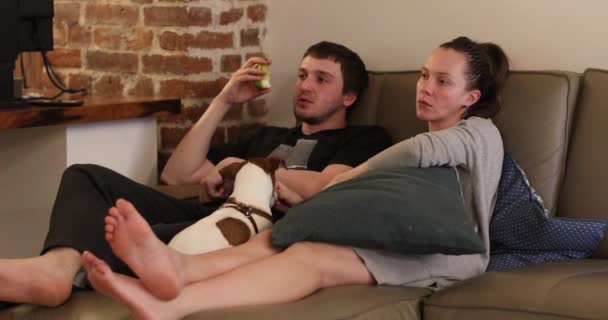 Pareja viendo la televisión en casa por la noche . — Vídeos de Stock