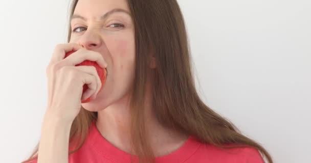 Frau isst großen roten Apfel weißen Hintergrund — Stockvideo