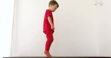 Smiling boy is tiptoeing