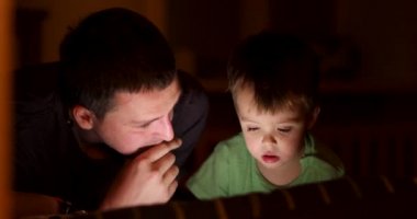 Baba oğul bir alet gecesi izliyorlar.