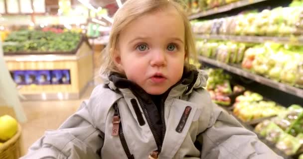 Niño en chaqueta caliente en el supermercado — Vídeo de stock