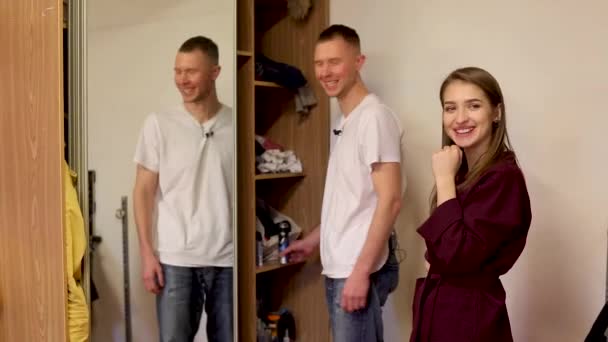 Cheerful stylist helping man to arrange clothes in wardrobe — ストック動画