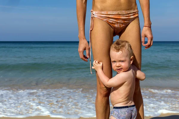 Piccolo bambino con madre in piedi sulla spiaggia — Foto Stock