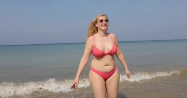 Tatmin olmuş bikinili tombul kadın tatilin tadını çıkarıyor.