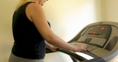 Spor giyim sektöründe isimsiz tombul bir bayan evde koşu bandında çalışıyor.