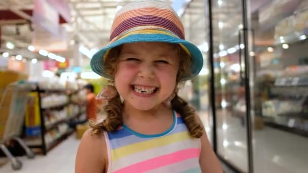 Alegre niña de pie en el supermercado — Vídeo de stock