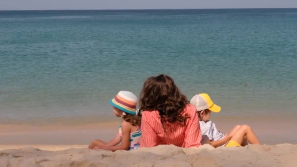 Mamma senza volto con bambini che riposano sulla spiaggia in estate — Video Stock