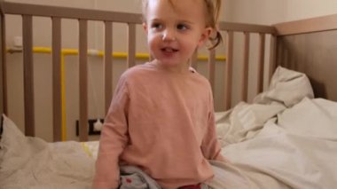 Cute toddler sitting on cot