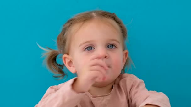 Beautiful little girl in studio points her nose — Αρχείο Βίντεο