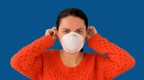 Женщина надевает хирургическую маску для профилактики коронного вируса — стоковое фото