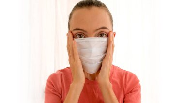 Corona virüsünün önlenmesi için cerrahi maske takan kadın.
