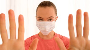 Corona virüsünün önlenmesi için cerrahi maske takan kadın.