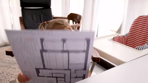 Curioso bambino piccolo esaminando progetto fingendo adulto nel posto di lavoro dei genitori a casa — Video Stock