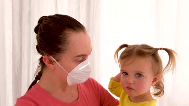 Donna in maschera protettiva con figlia malata triste in clinica moderna — Video Stock