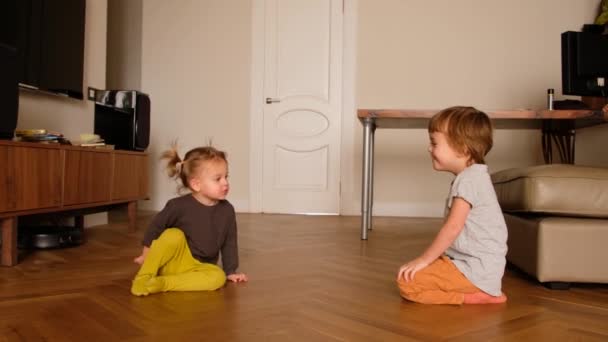 Χαρούμενο αγοράκι που παίζει με την αδερφή του στο σπίτι. — Αρχείο Βίντεο