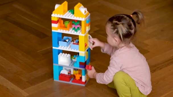 Klein meisje spelen met speelgoed huis — Stockvideo
