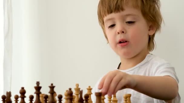 Cute little boy playing chess — Stock Video