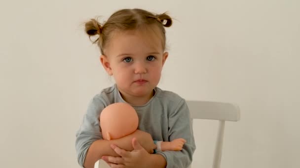 Linda niña abrazando muñeca — Vídeo de stock