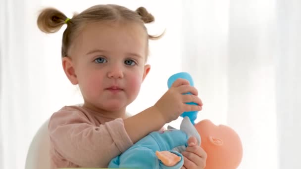 Menina alimentando boneca em casa — Vídeo de Stock