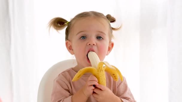 Смешная девушка ест свежий банан — стоковое видео