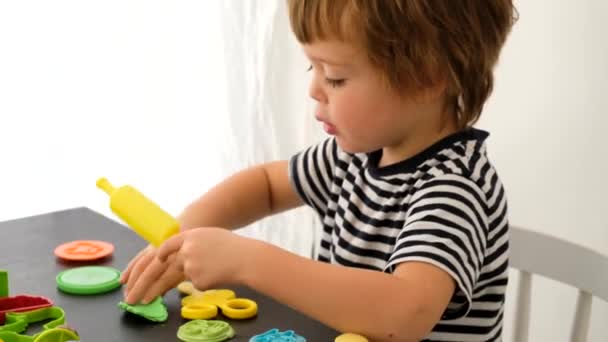 Αγόρι παίζει με πολύχρωμο πηλό μοντελοποίησης — Αρχείο Βίντεο