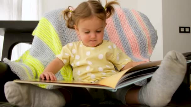 Χαριτωμένο βιβλίο ανάγνωσης μικρών παιδιών στο σπίτι — Αρχείο Βίντεο