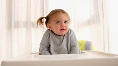 Yüksek sandalyede oturan güvenilmez çocuk.