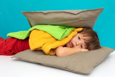 Üzgün küçük çocuk evde hamburger gibi yatıyor.