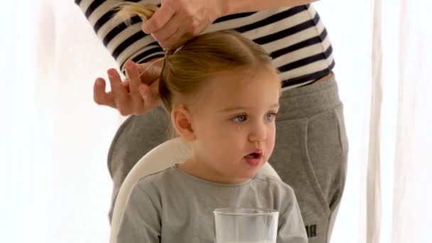 La madre di raccolto che fa capelli di figlia in mattina — Video Stock