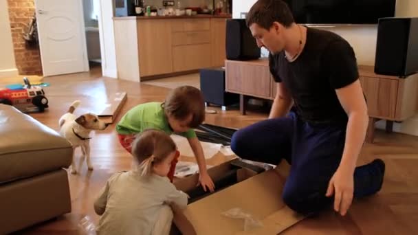 Père et enfants assemblant des meubles à la maison — Video