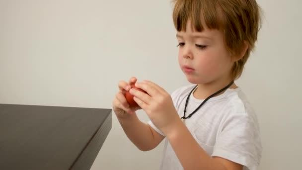 Boy knocking Easter egg on table — Stock Video