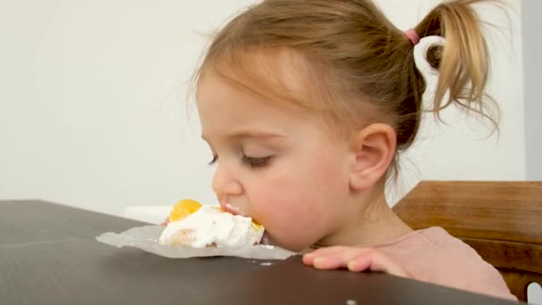 Kleines Mädchen isst Dessert vom Tisch — Stockvideo