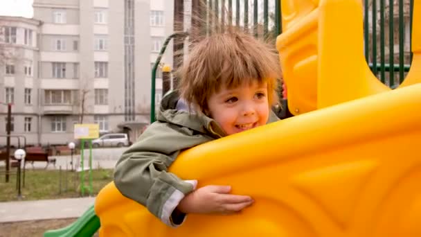 Aufgeregter Junge spielt auf Spielplatz — Stockvideo