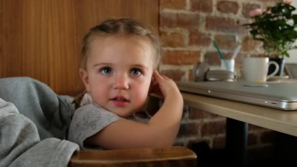 Niño sentado cerca de la mesa con portátil — Vídeo de stock