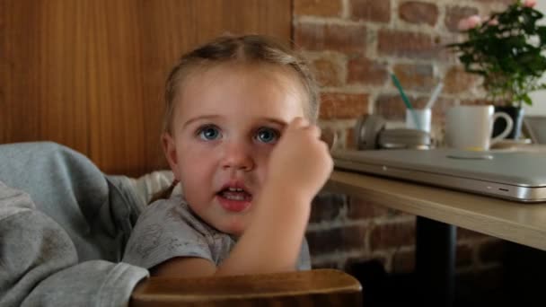 Niño sentado cerca de la mesa con portátil — Vídeos de Stock