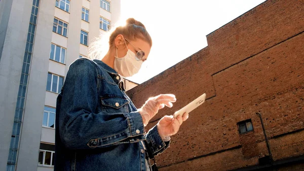 Женщина в защитной маске и очках со смартфоном — стоковое фото