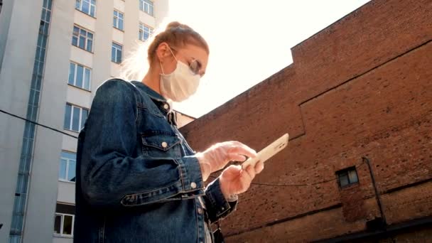 Vrouw met beschermend masker en bril met smartphone — Stockvideo