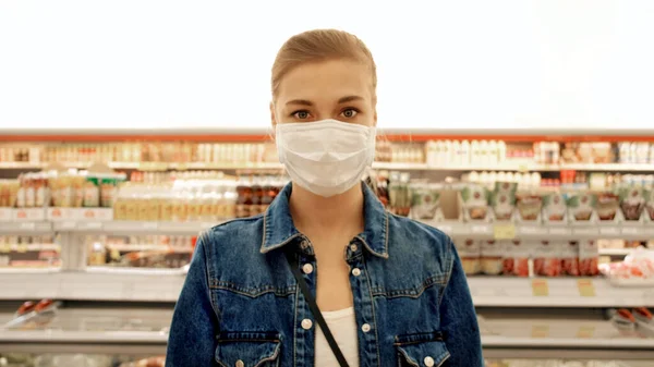 Женщина в защитной маске в магазине — стоковое фото