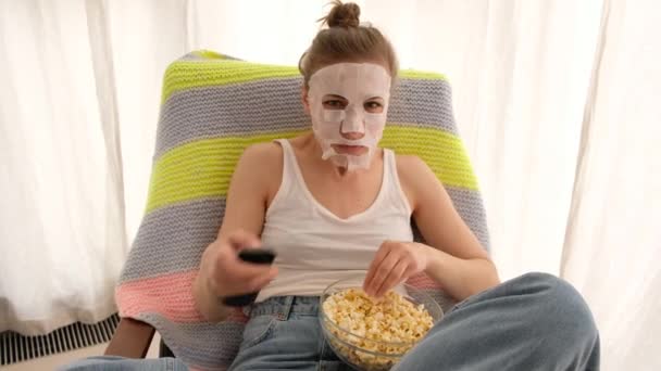 Mujer con un control remoto y palomitas de maíz — Vídeos de Stock