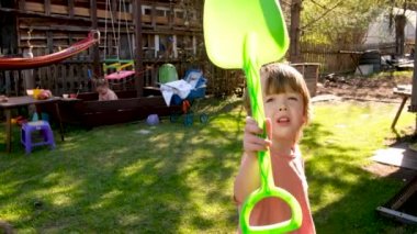 Anaokulu çocukları güneşli bir günde kır evinin bahçesinde eğleniyorlar.