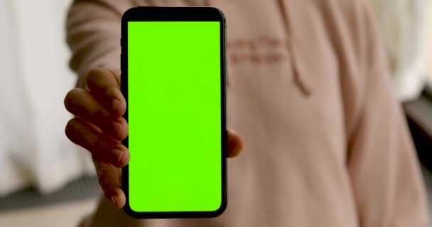 Frau zeigt Smartphone mit grünem Bildschirm — Stockvideo