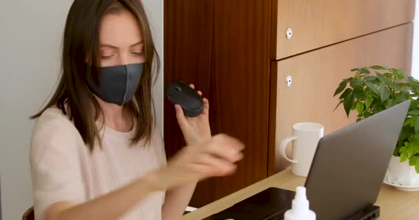 Frau in Maske hantiert mit Laptop-Desinfektion — Stockvideo