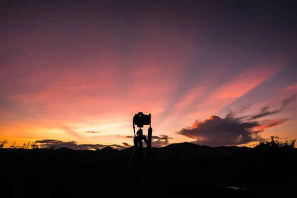 Gündoğumu gökyüzü ile tripod üzerinde kamera silüeti — Stok fotoğraf