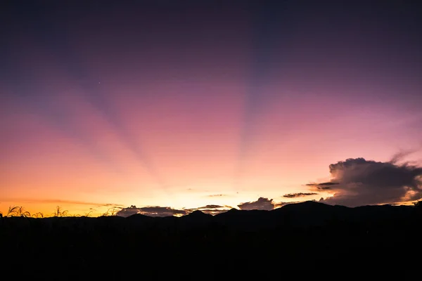 Silueta de imagen de montaña y puesta de sol cielo en el fondo. —  Fotos de Stock