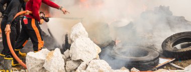 İtfaiyeciler yangına su hortumu kullanarak